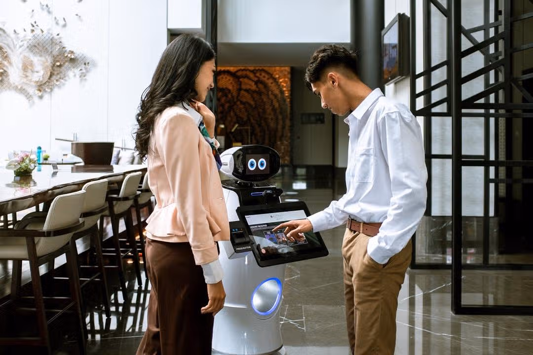 Mano, robot AI di lobi hotel Pullman Bandung Grand Central yang sedang menyapa tamu.