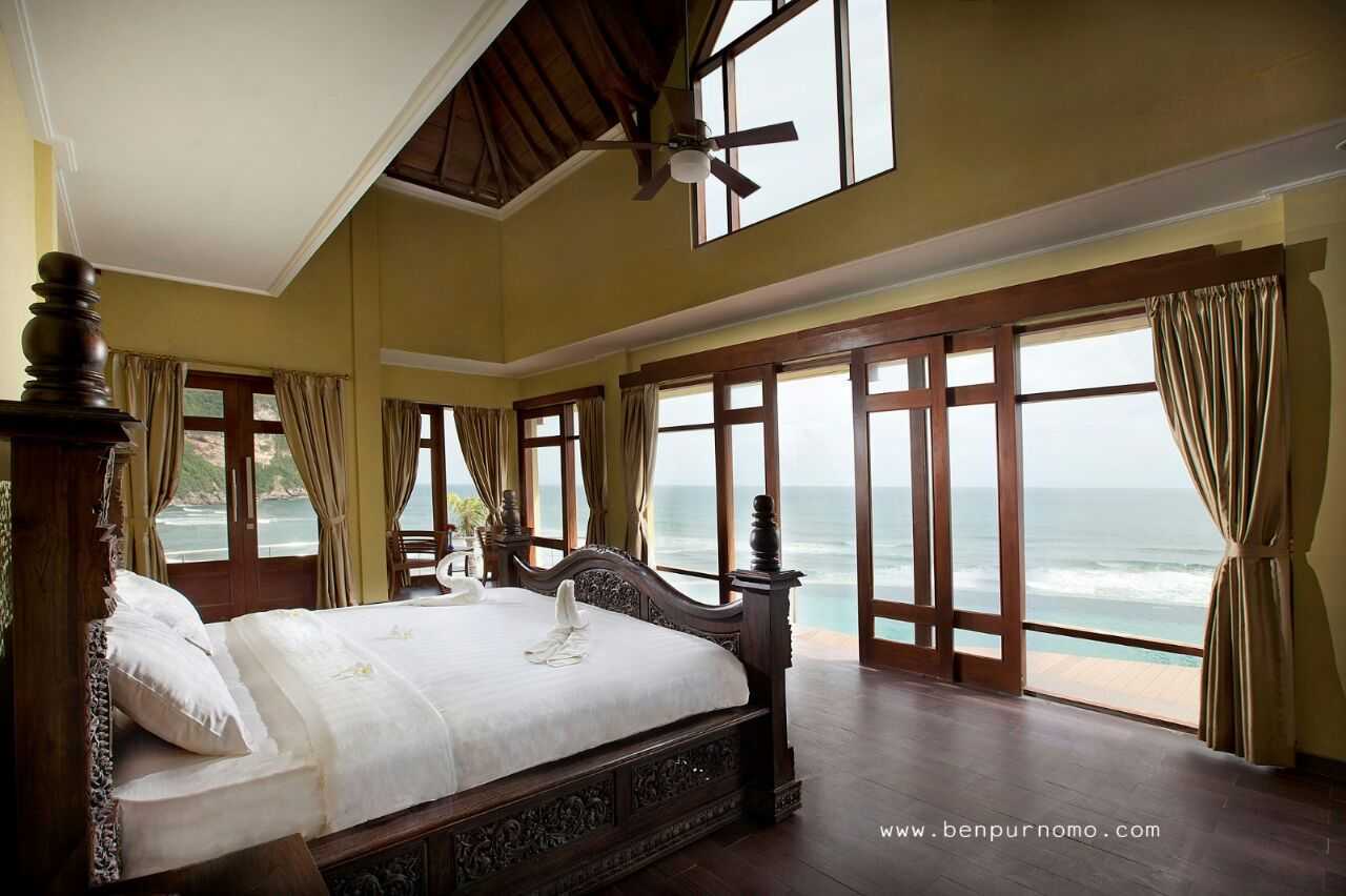 interior kamar dengan balkon menghadap laut.