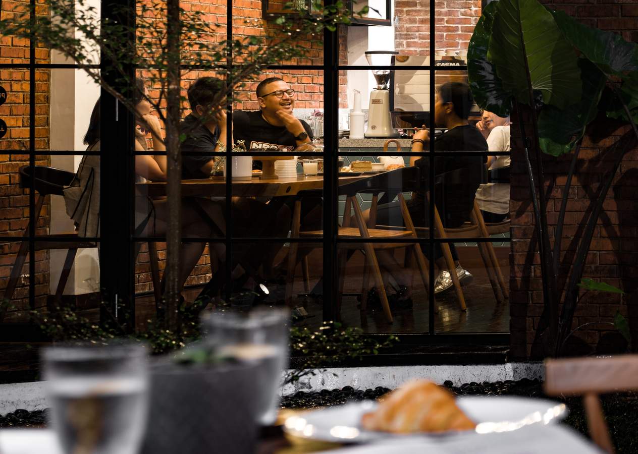 suasana tamu sedang menikmati kopi di cafe