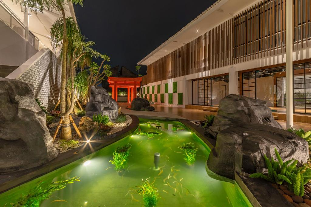 A luxurious infinity pool overlooking a tropical garden with aesthetic wooden sun loungers and white towels.