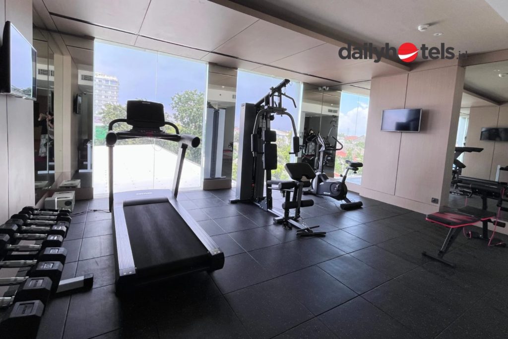 A clean and modern gym area with new fitness equipment including treadmills, weights, and workout benches, featuring bright lighting and a contemporary interior design at Swiss-Belexpress Jemursari Surabaya.
