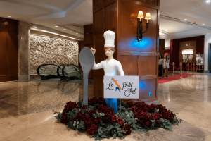 Dekorasi Le Petit Chef dengan patung koki dan sendok raksasa di lobi hotel