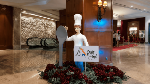 Dekorasi Le Petit Chef dengan patung koki dan sendok raksasa di lobi hotel