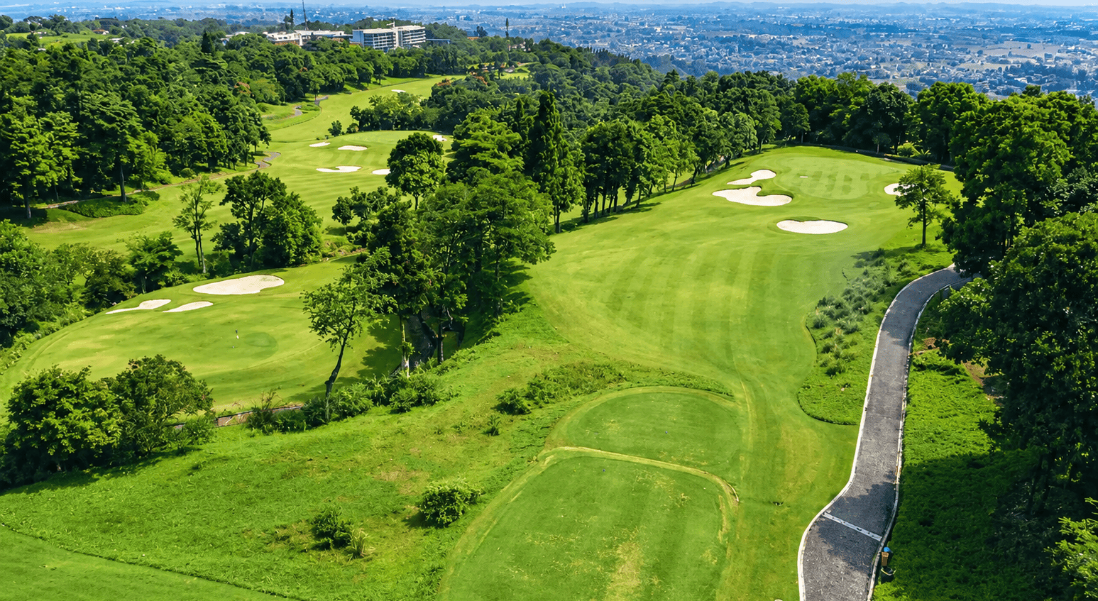 Lapangan golf hijau di kawasan Gunung Geulis dengan pemandangan perbukitan dan kota dari kejauhan