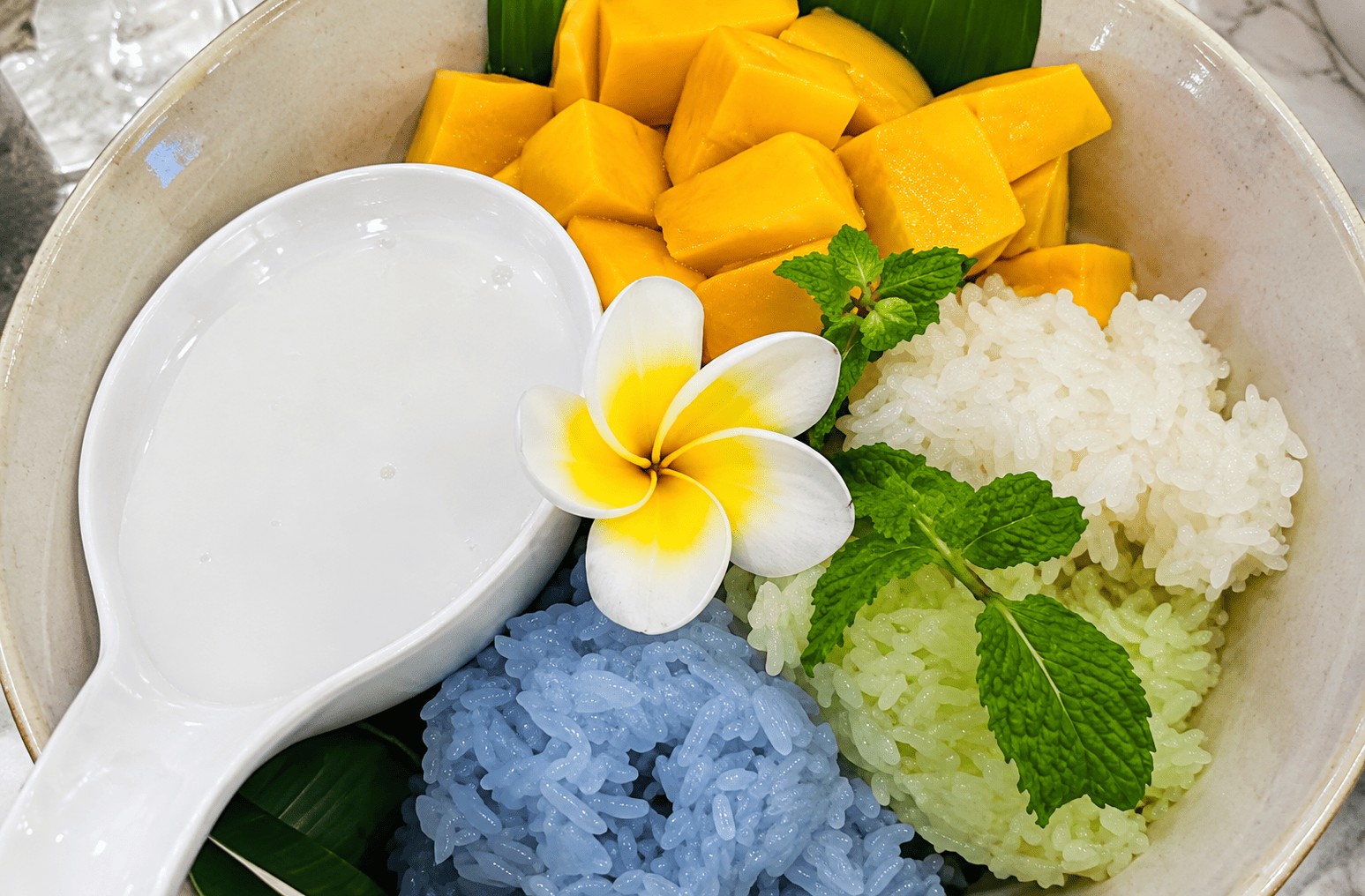 Mango Sticky Rice dengan potongan mangga dan ketan warna-warni di Kin Kao