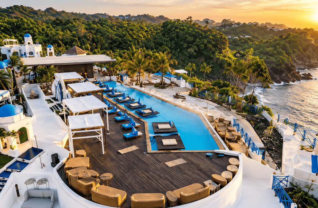Jungwok Blue Ocean Resort dengan kolam renang dan area bersantai menghadap laut saat matahari terbenam.