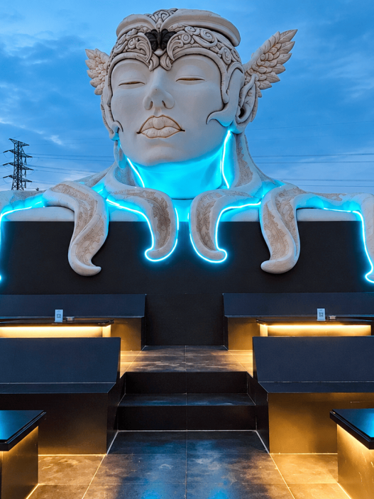 Patung ikonik di area GUA Art Resort Bandung dengan pencahayaan biru