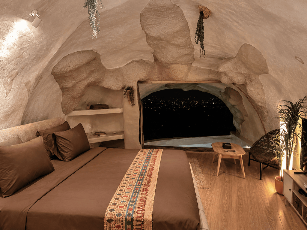 Kamar GUA Art Resort Bandung dengan desain interior menyerupai gua dan pemandangan city light
