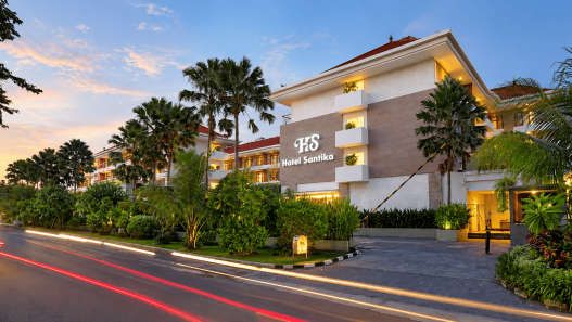 Hotel Santika dengan arsitektur modern, taman tropis, dan suasana senja