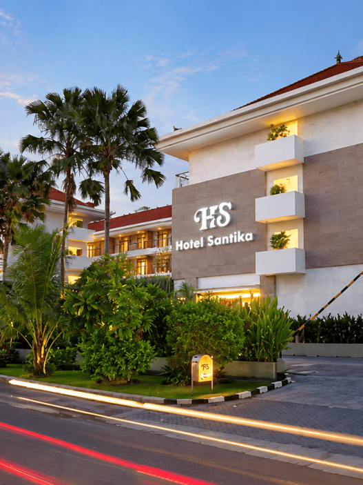 Hotel Santika dengan arsitektur modern, taman tropis, dan suasana senja