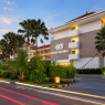 Hotel Santika dengan arsitektur modern, taman tropis, dan suasana senja