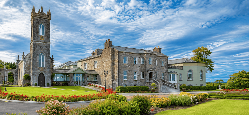 Glenlo Abbey di Galway dengan bangunan batu bersejarah, menara gereja, taman hijau, dan lanskap sekitar