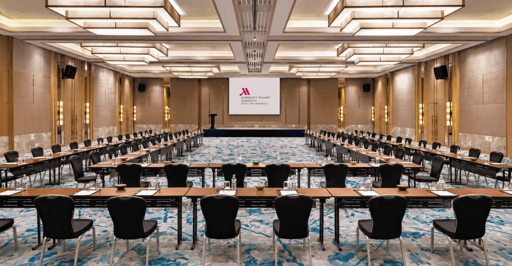 Meeting room hotel dengan proyektor dan tata kursi U-shape untuk rapat bisnis