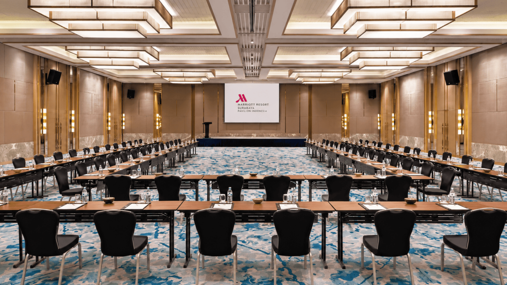 Meeting room hotel dengan proyektor dan tata kursi U-shape untuk rapat bisnis