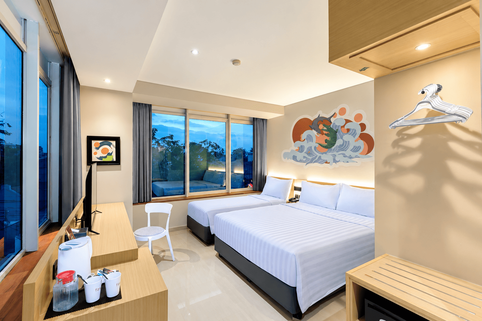 Interior Family Room fave hotel MEX Tunjungan Surabaya dengan satu Queen Bed, satu Twin Bed, serta fasilitas kamar bernuansa modern.