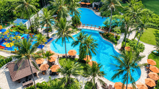 Shangri-La Jakarta — kolam renang tropis dengan area hijau dan pohon palem