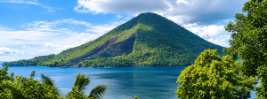 Pemandangan alam Banda Neira dengan gunung berapi hijau dan laut biru yang jernih.