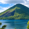 Pemandangan alam Banda Neira dengan gunung berapi hijau dan laut biru yang jernih.