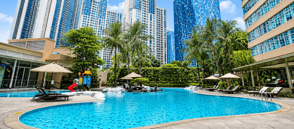 Kolam renang outdoor Wyndham Casablanca Jakarta dengan suasana tropis dan gedung-gedung tinggi di sekitarnya.