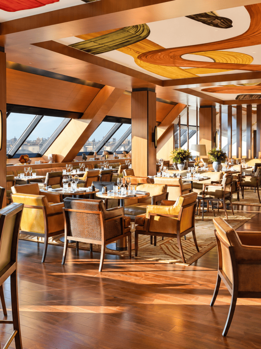Interior restoran mewah Hôtel Madame Rêve Paris dengan desain modern elegan dan pemandangan kota.