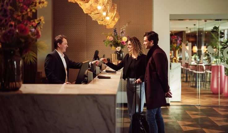 Staf resepsionis hotel melayani tamu saat proses check-in