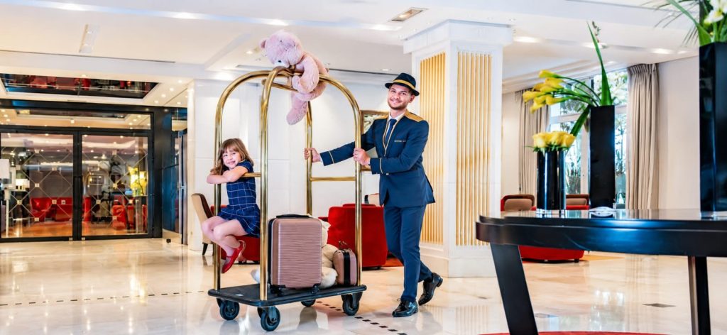 Bellboy membantu tamu membawa barang bawaan setibanya di hotel