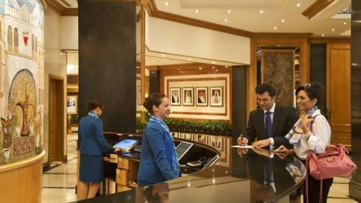 Proses check-in tamu di meja resepsionis hotel