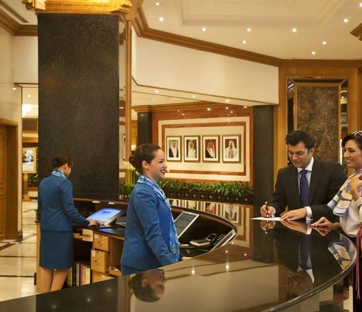 Proses check-in tamu di meja resepsionis hotel