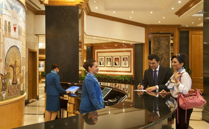 Proses check-in tamu di meja resepsionis hotel